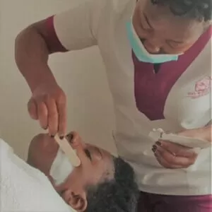 A beautician with Viv's in-Houz spa applying face mask on a client's face during a deep cleanse facial treatment