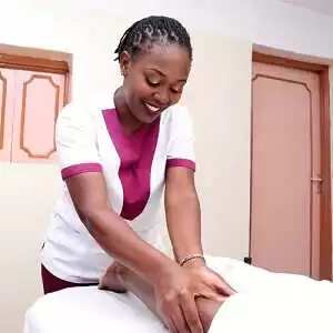 A massage therapist with Viv's in-Houz Spa, a mobile wellness spa in Nairobi, doing massage to a client at the clients home.